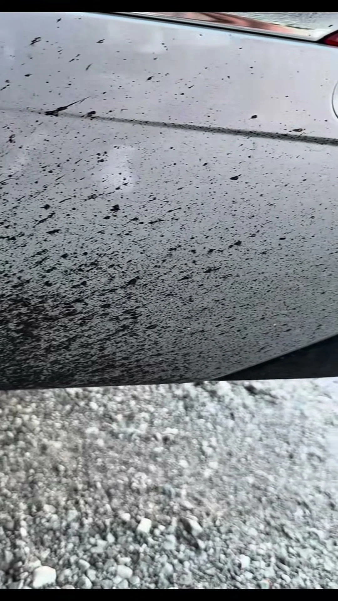 Road tar on the lower panel of a silver SUV